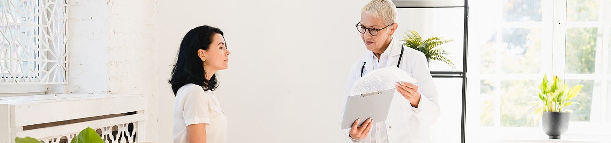 Gespräch zwischen Patientin und Ärztin – Symbolbild für die Frage: Wann zum Arzt bei PMS und Regelbeschwerden?