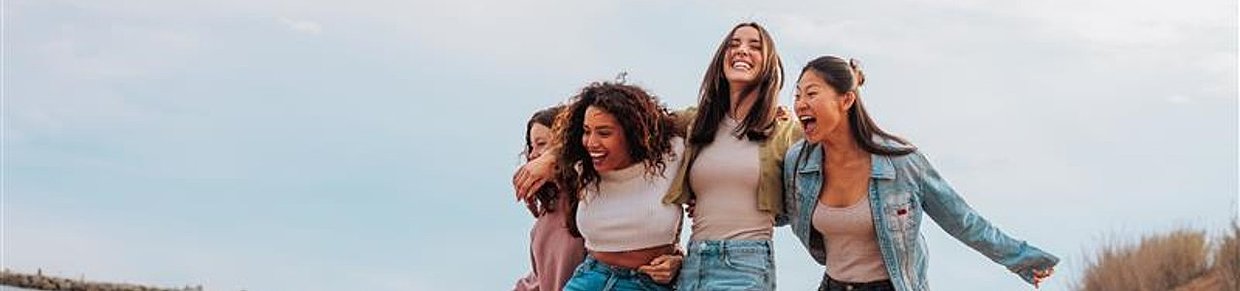 Lachende Frauen am Strand – Symbolbild für Lebensfreude und gemeinsame Wege zur Behandlung von Regelbeschwerden